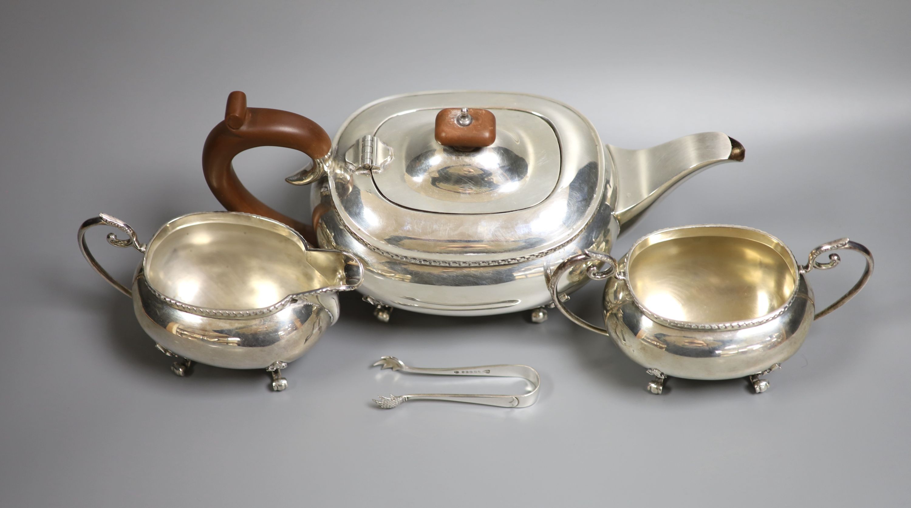 A modern silver three piece tea set by Joseph Gloster Ltd, Birmingham, 1974, gross weight 33oz and a pair of plated sugar tongs.